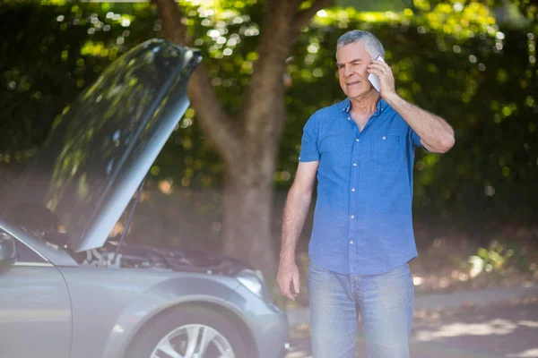 Idősebb ember beszél telefonon autó bontás — Stock Fotó