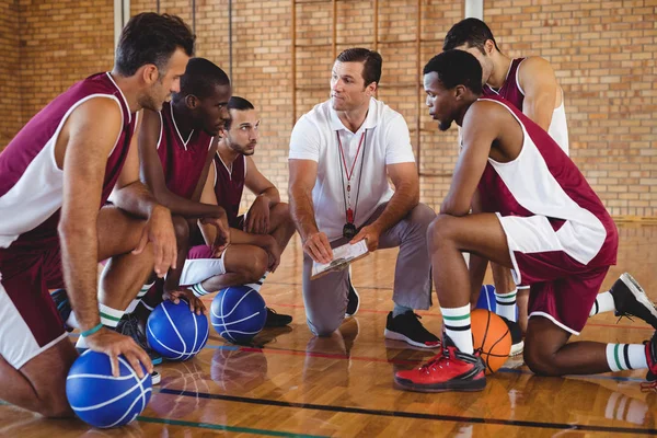 Treinador explicando plano de jogo para jogadores de basquete — Fotografia de Stock