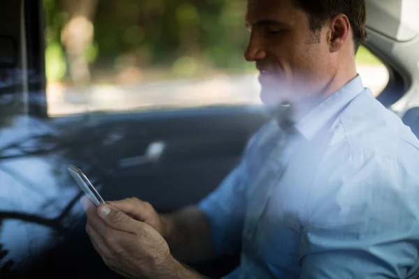 Mężczyzna korzystający z telefonu komórkowego w samochodzie — Zdjęcie stockowe