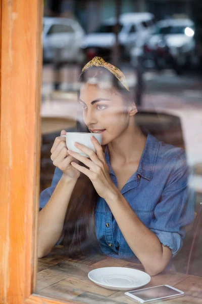 Promyšlené žena pití kávy v kavárně obchod — Stock fotografie