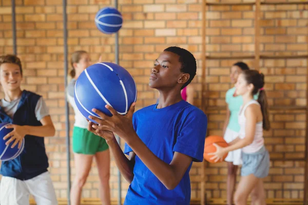 Menino do ensino médio olhando para o basquete — Fotografia de Stock