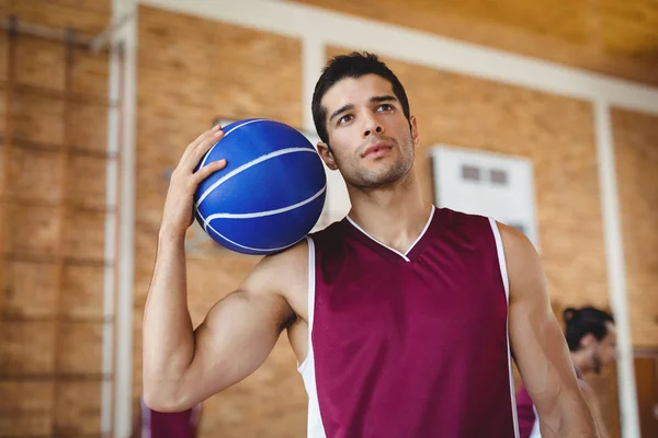 Determined basketball player holding basketball — Stock Photo, Image