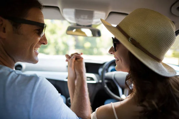 Пара, держащаяся за руки во время путешествия в машине — стоковое фото