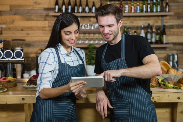 Garçom e garçonetes usando tablet no balcão — Fotografia de Stock