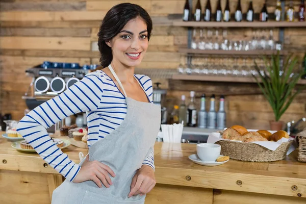 Chelneriță în picioare cu mâna pe șold la tejghea — Fotografie, imagine de stoc