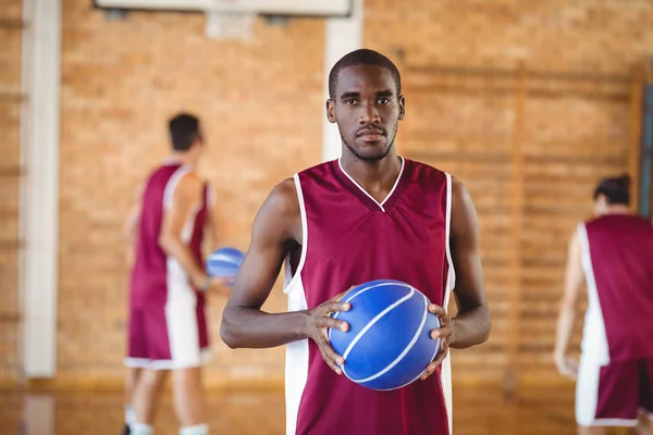 Selbstbewusster Basketballspieler mit Basketballkorb — Stockfoto