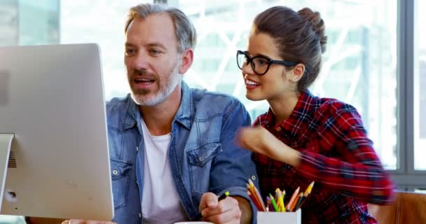 Diseñadores gráficos masculinos y femeninos trabajando juntos en el escritorio — Vídeos de Stock