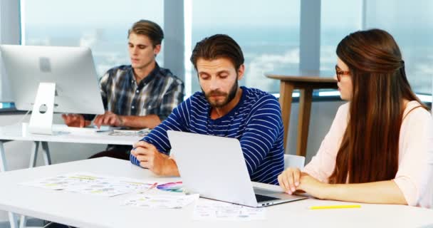 Designers gráficos discutindo sobre laptop na mesa — Vídeo de Stock