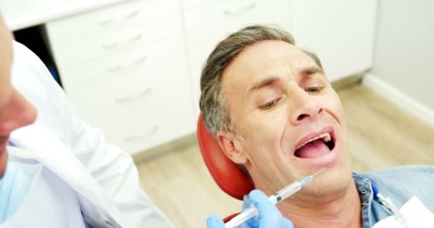 Uomo spaventato che riceve l'iniezione dal dentista — Video Stock