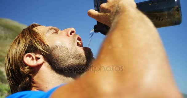 Triathlete άνθρωπος πόσιμου νερού σε μια ηλιόλουστη ημέρα — Αρχείο Βίντεο