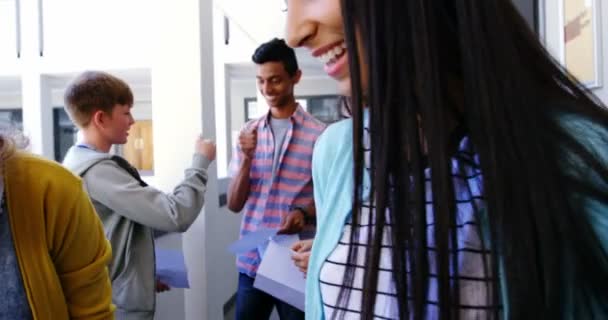 Estudiantes sonrientes dándose el puño en el pasillo — Vídeo de stock