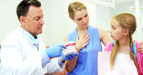 Dentysta, pokazując młodego pacjenta jak szczotkować zęby — Wideo stockowe
