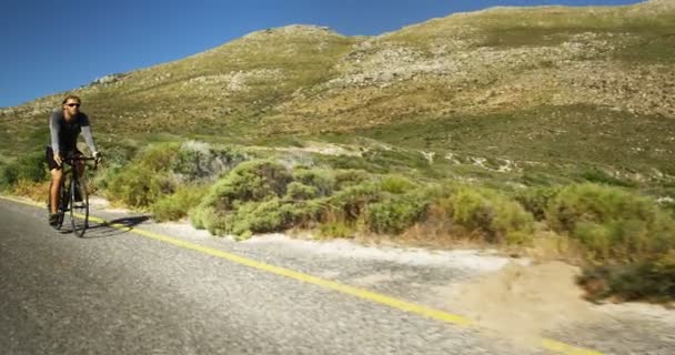 Triatleet man fietsen in de weg van het platteland — Stockvideo
