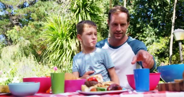 Pai e filho tendo refeição na casa do jardim — Vídeo de Stock
