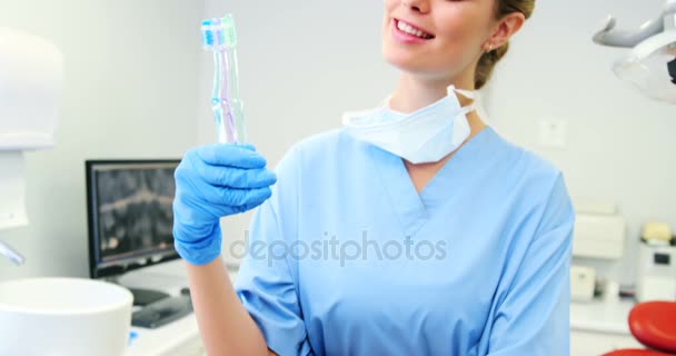 Retrato de una enfermera sosteniendo cepillos de dientes — Vídeo de stock