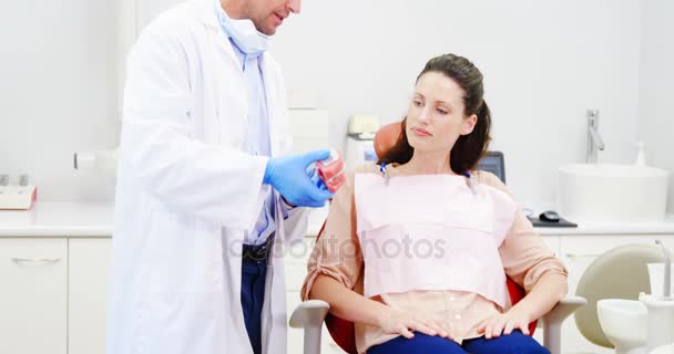 Dentista mostrando modelo de dientes al paciente — Vídeo de stock