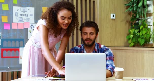 Twee leidinggevenden bespreken over laptop aan balie — Stockvideo