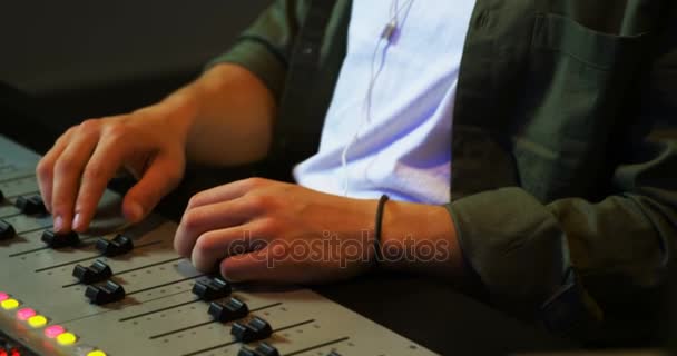 Mannelijke audio engineer hoofdtelefoon beluisteren tijdens het mixen van geluid — Stockvideo