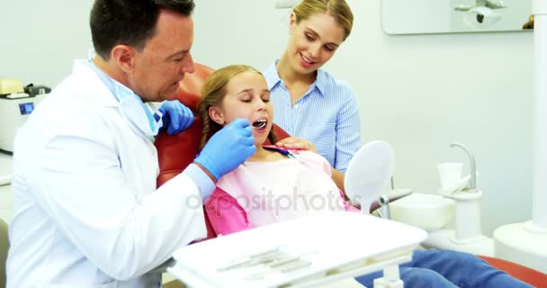 Dentista examinando a un paciente joven con herramientas — Vídeo de stock