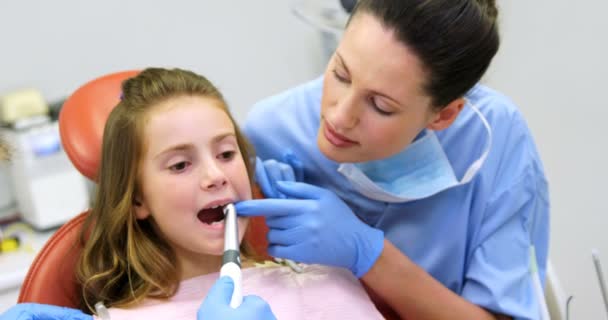 Стоматолог и медсестра осматривают молодого пациента с помощью инструментов — стоковое видео