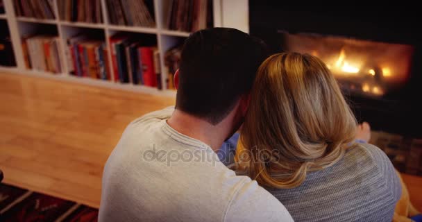 Paar ontspannen bij de open haard in de woonkamer — Stockvideo