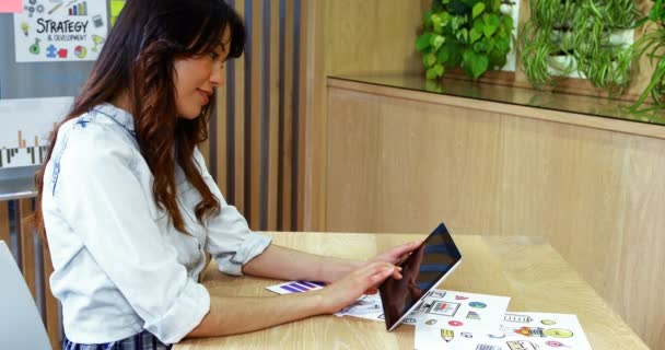Улыбающаяся исполнительная женщина с помощью цифрового планшета за столом — стоковое видео