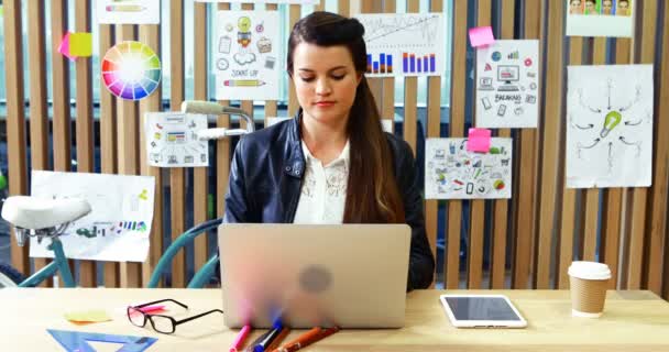 Ejecutiva femenina usando portátil y tableta digital en el escritorio — Vídeos de Stock