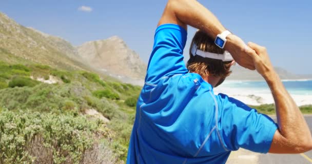 Vista trasera del hombre triatleta haciendo ejercicio en un día soleado — Vídeo de stock