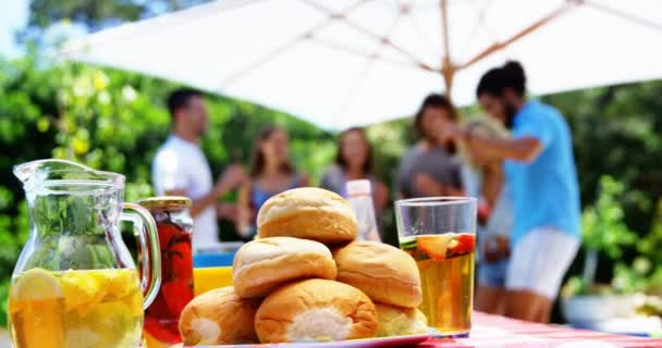 Close-up van SAP en broodjes geserveerd op tafel op openlucht barbecue feest — Stockvideo