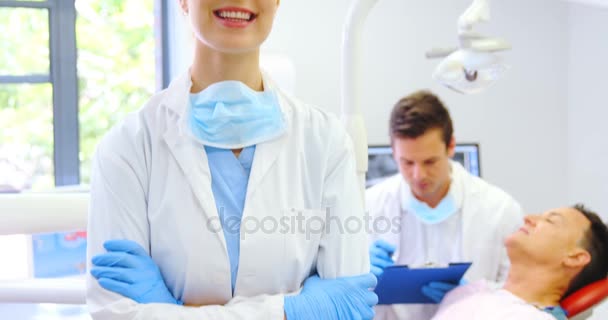 Портрет улыбающегося стоматолога, стоящего со скрещенными руками — стоковое видео