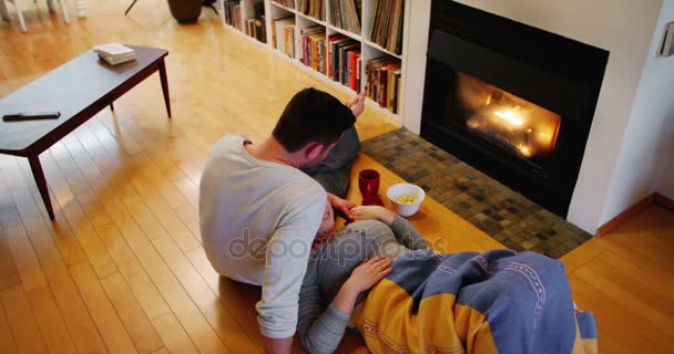 Paar entspannt am Kamin im Wohnzimmer — Stockvideo