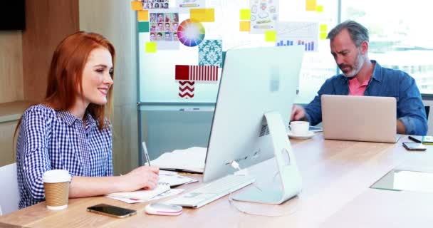 Ejecutivos masculinos y femeninos trabajando juntos en el escritorio — Vídeo de stock