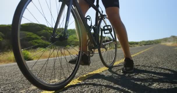 Triatleta homem de bicicleta em um dia ensolarado — Vídeo de Stock