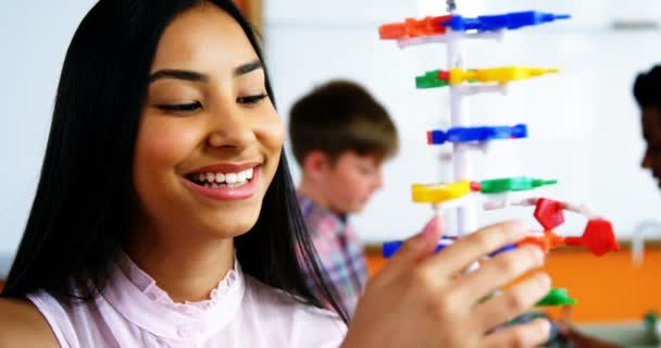 Schoolmeisje experimenterende molecuul model in laboratorium op school — Stockvideo