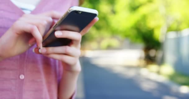 Schoolmeisje met behulp van mobiele telefoon — Stockvideo