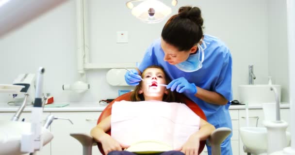 Dentista examinando um paciente jovem com ferramentas — Vídeo de Stock