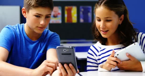 Studenti che utilizzano tablet digitale e telefono cellulare in classe — Video Stock