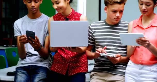 Estudiantes usando laptop, teléfono móvil y tableta digital — Vídeo de stock