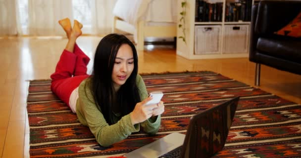 Vrouw met mobiele telefoon in de woonkamer — Stockvideo