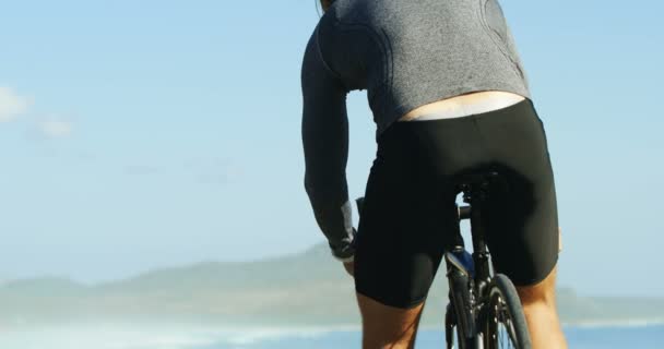 Vista posteriore dell'uomo triatleta che si prepara a guidare un ciclo — Video Stock