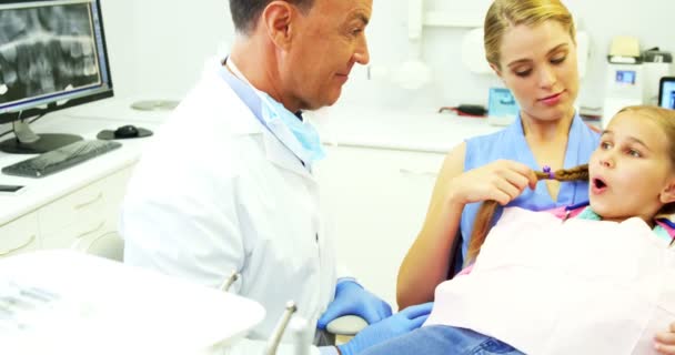 Tandläkare visar ung patient hur man borstar tänder — Stockvideo