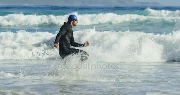 Surfista masculino correndo na praia — Vídeo de Stock