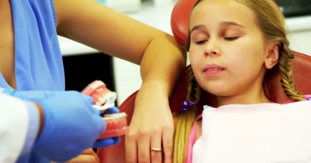 Dentista mostrando al paciente joven cómo cepillarse los dientes — Vídeo de stock