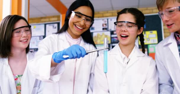Улыбающиеся школьники проводят химический эксперимент в лаборатории — стоковое видео