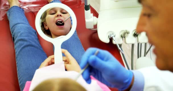 Dentista examinando um paciente jovem com ferramentas — Vídeo de Stock