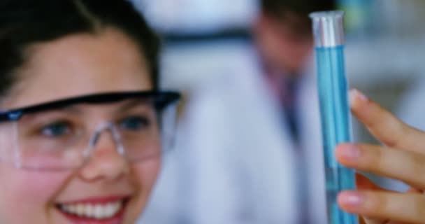 Escolar sonriente haciendo un experimento químico en laboratorio — Vídeos de Stock