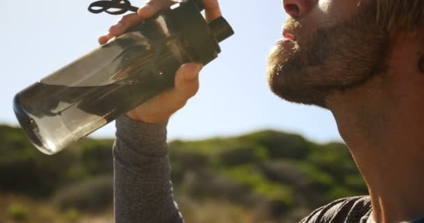 Triatleta hombre beber agua en un día soleado — Vídeos de Stock