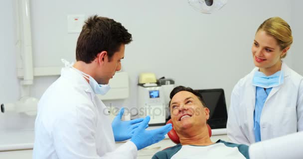 Dentistas que interactúan con un paciente masculino — Vídeo de stock
