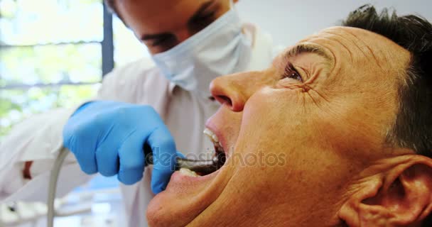 Dentista examinando um paciente do sexo masculino com ferramentas — Vídeo de Stock