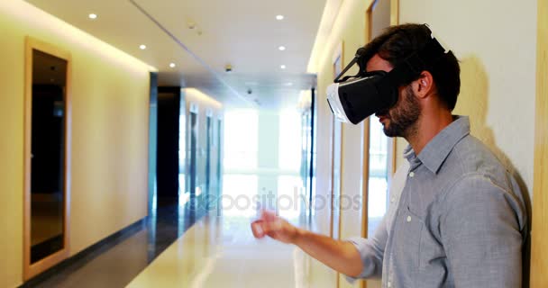 Male executive using virtual reality headset in corridor — Stock Video